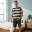 Man wearing a green and grey striped tee with dark green shorts