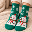 Green Christmas socks with white snowflakes and a snowman wearing a red hat and scarf