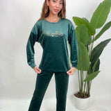 Close up of a dark green velvet pajama top with gold Special One lettering
