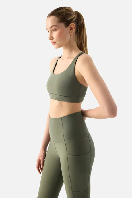 Woman wearing a green athletic outfit on a white background