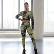 Woman wearing a green and black tie-dye athletic outfit in a modern indoor setting