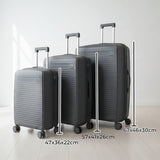 Dark grey suitcase set with telescopic handles raised in a bright room
