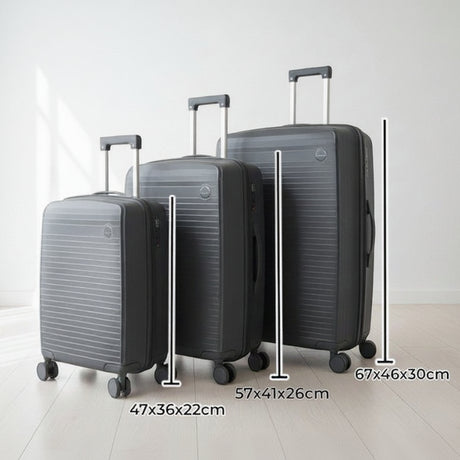 Dark grey suitcase set with telescopic handles raised in a bright room