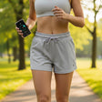 Person in athletic wear holding a phone in a park