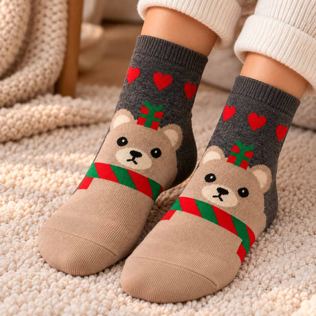 Grey and beige Christmas socks with red hearts and a teddy bear wearing a red and green striped scarf