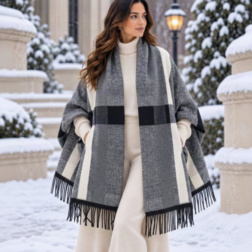 Light grey block check blanket wrap with cream stripes and black fringe worn over a cream outfit in the snow