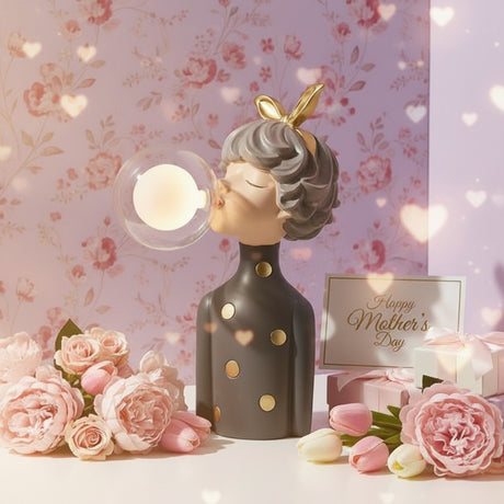 Charcoal figure with gold spots, her lit glass globe glowing against floral wallpaper