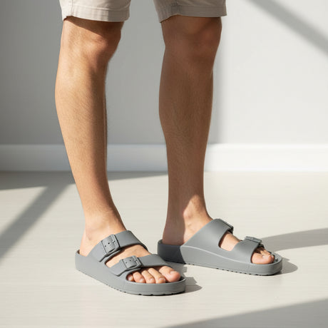 Pair of grey sandals on a white floor