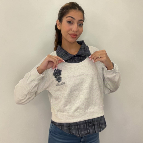 Check collar pulled open on a marled grey sweatshirt with a check shirt hem