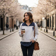 Woman wearing a grey check collar sweatshirt on a blossom lined street