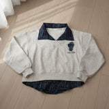 Grey sweatshirt with a navy check collar and shirt hem laid flat
