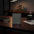 Gray notebook with 'boellery' branding on a wooden desk with a cup of coffee and glasses.