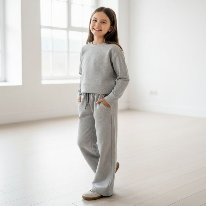Girl in a grey sweatshirt and matching wide leg pants with pockets