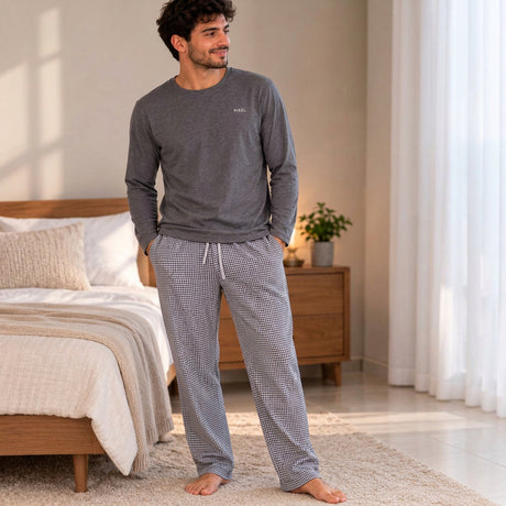 Full length view of a grey crew neck pyjama top with small check trousers in a bright bedroom