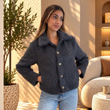 Grey fluffy jacket buttoned to the collar, hands in pockets, with light wash jeans
