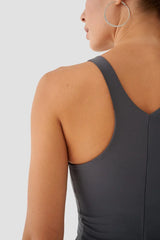 Person wearing a grey tank top on a plain background