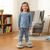 Girl in star print pyjamas wearing grey plush shark slippers with soft fins