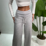 Close up of the ribbed fold over waistband and white drawstring on grey sweatpants