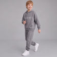 Smiling boy in a grey Follow Your Dreams hoodie and matching joggers