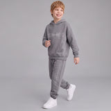 Smiling boy in a grey Follow Your Dreams hoodie and matching joggers