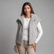 Pearl grey hooded faux fur vest over a white long sleeve top