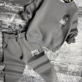Grey sweatshirt and joggers set laid flat with small front graphic