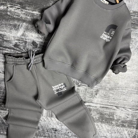 Grey sweatshirt and joggers set laid flat with small front graphic
