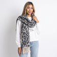 Grey and cream leopard print winter scarf worn looped twice with thick knotted fringe