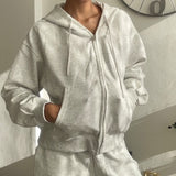 Woman in a grey marl oversized zip hoodie with drawstring hood and matching sweatpants
