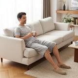 Grey pantacour pyjama set worn relaxing on a cream sofa with coffee