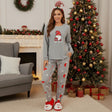 Grey Christmas pajama set with a red hat gnome print top and candy cane print pants, worn by a decorated tree