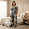 Woman wearing a grey plaid shirt and matching plaid shorts standing beside a bed - Jack Gifts Online Lebanon