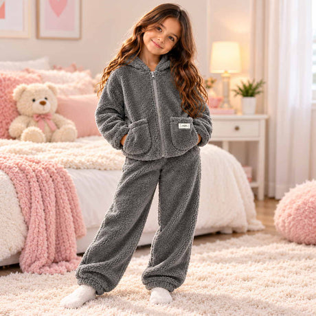 Grey sherpa fleece kids pajama set with zip up jacket and matching pants in a cozy bedroom