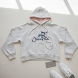Blush pink hood lining and kangaroo pocket shown on the grey hoodie