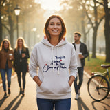 Grey slogan hoodie styled with jeans on a tree lined path