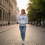 Woman wearing a grey marl hoodie with a navy script slogan and red dot accents