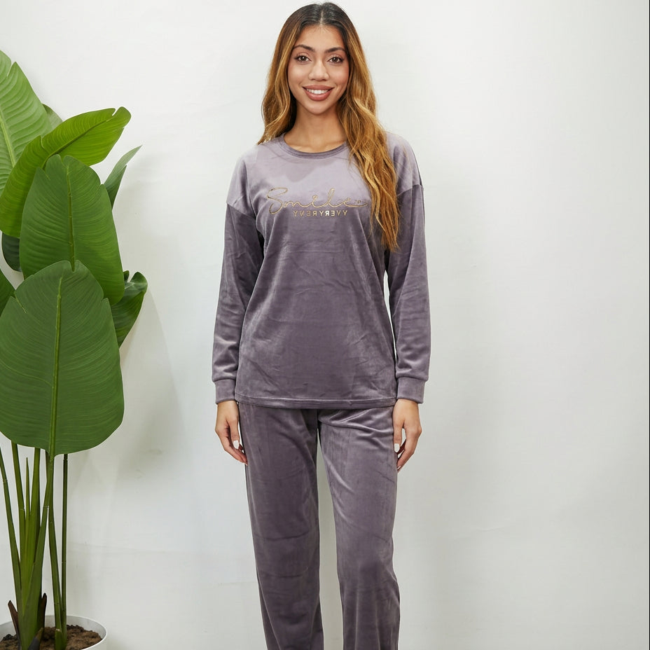 Woman in a grey velvet PJ set with a Smile Every Day gold script print top and matching pants
