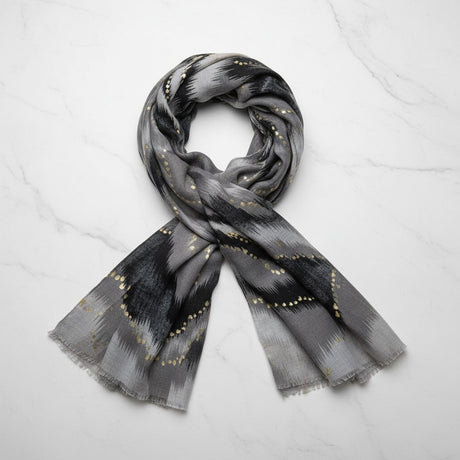 Grey scarf with black and gold pattern on a white background