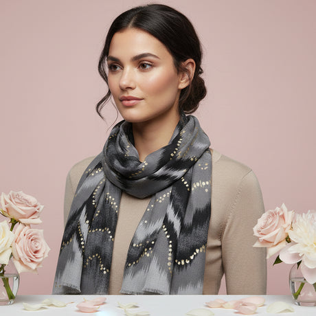 Woman wearing a grey patterned scarf with pink roses in the background