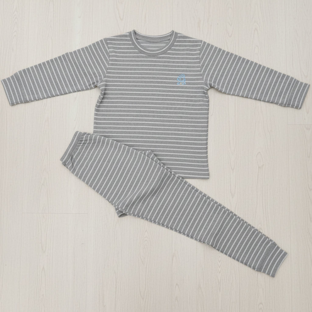 Grey and white stripe kids pyjama set laid flat on a wood floor, crew neck top with cuffed joggers