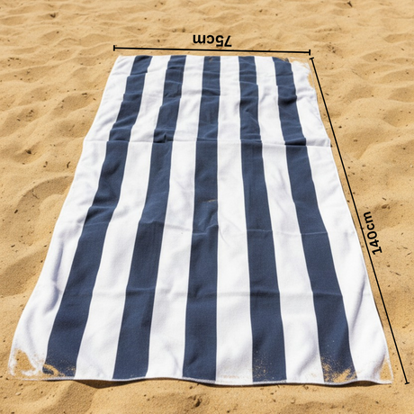 Grey and white striped beach towel on sand with 75x140 cm size measurements indicated