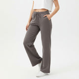 Woman wearing grey pants and a white top on a white background