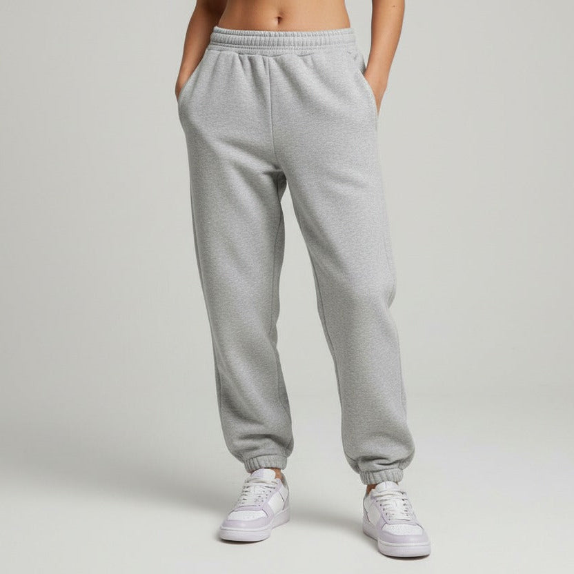Grey sweatpants worn by a person on a plain background
