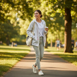 Grey hoodie worn open over a white tee on a sunny park path