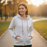 Grey tassel zip hoodie worn in a park at golden hour