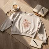 Grey marl tulip print sweatshirt laid flat on a jute rug with coffee and a book