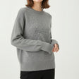 Grey crew neck wool sweater featuring a tonal textured flower motif across the chest