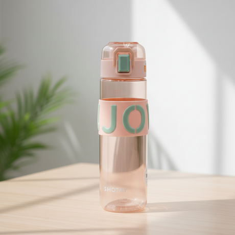 Clear water bottle with pink top and 'JO' label on a light surface with a plant in the background