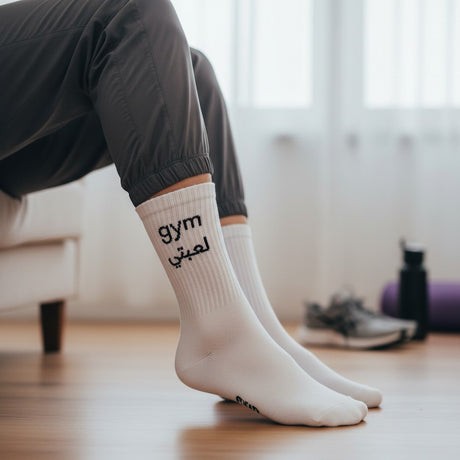 Person wearing white socks with 'gym' text in a home setting