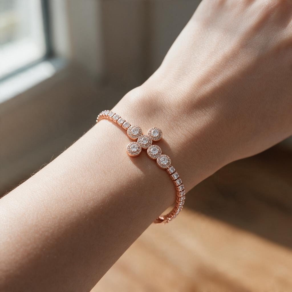 Rose gold halo cross tennis bracelet with round crystal clusters worn on the wrist